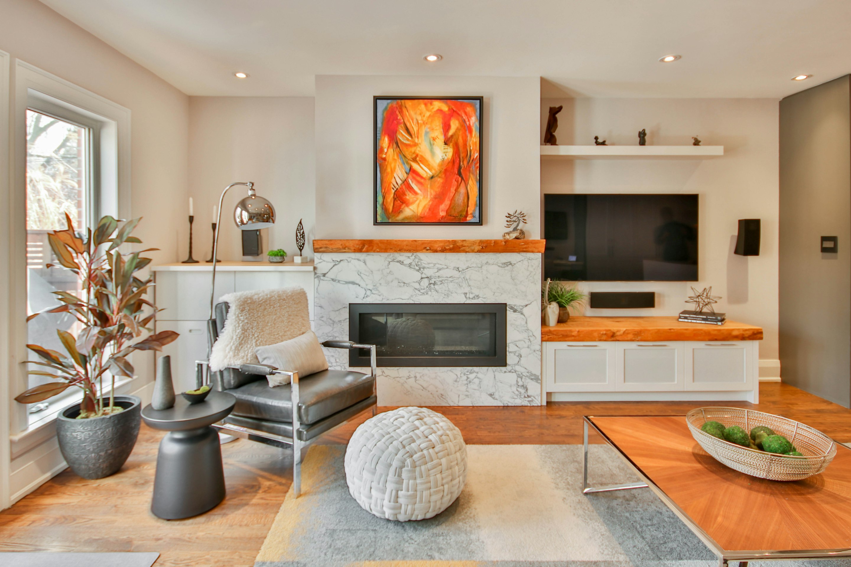 A warmly lit residential interior with marble fireplace and wood accents